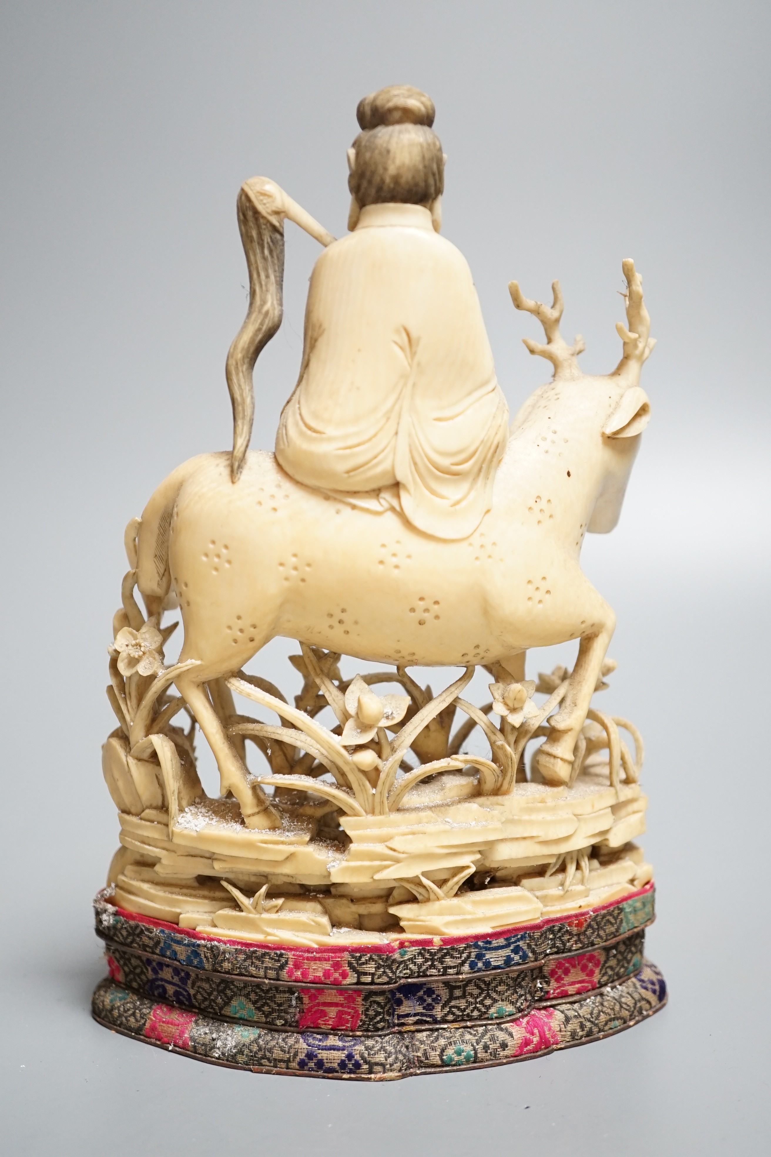 A Chinese carved ivory figure of a female immortal riding a deer, early 20th century, height 17cm excl. stand